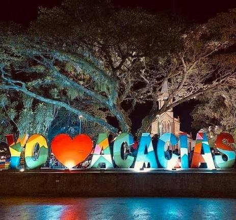Las letras de Acacías iluminadas de noche bajo un árbol de samán