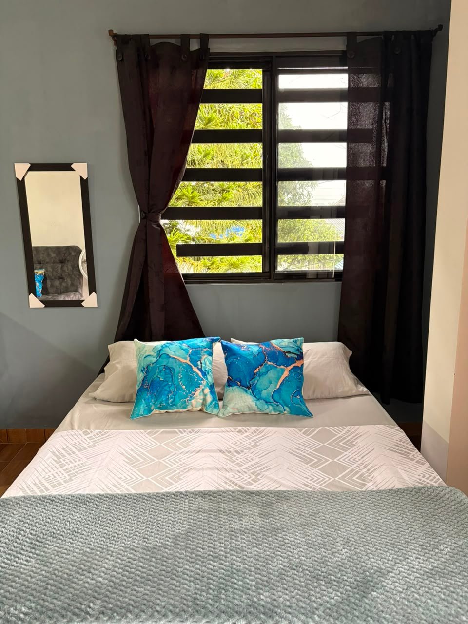 Laguna Vieja: cama doble frente a la ventana, con vegetación al fondo