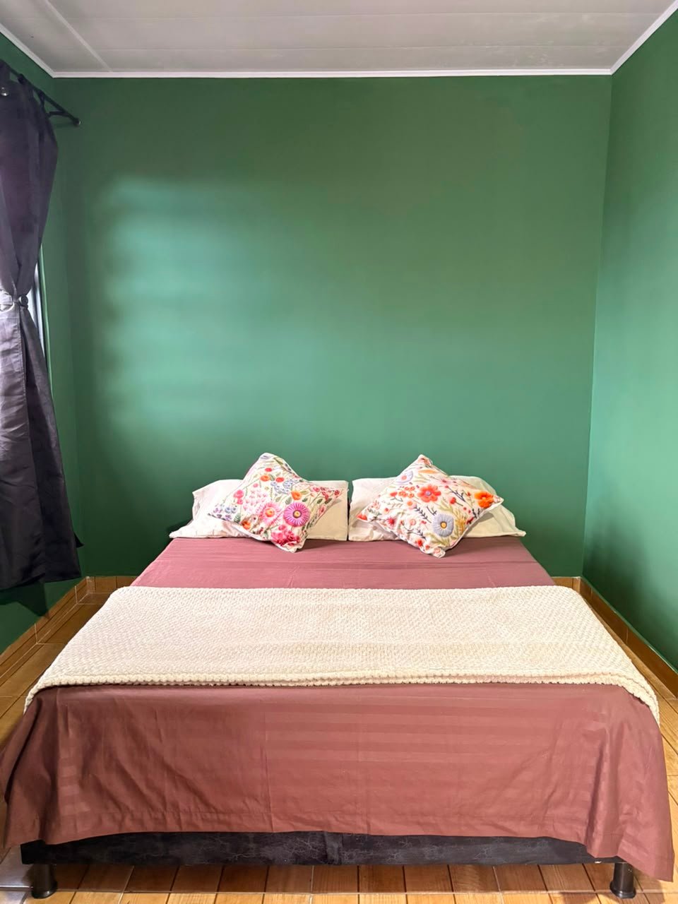 Morichal: cama doble con cojines florales, vista frontal